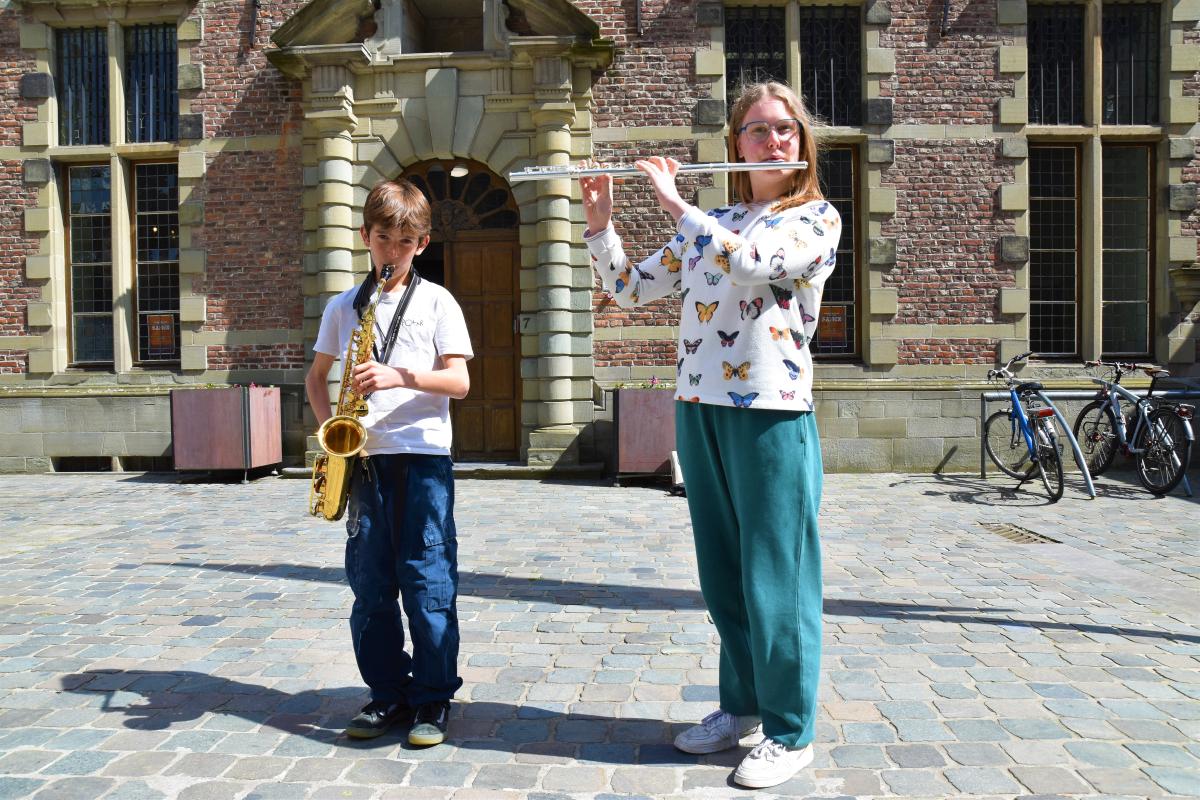 Brando Aerts en Lore Lamote spelen muziek aan de ingang van de campus Servais van de Kunstacademie in Halle.