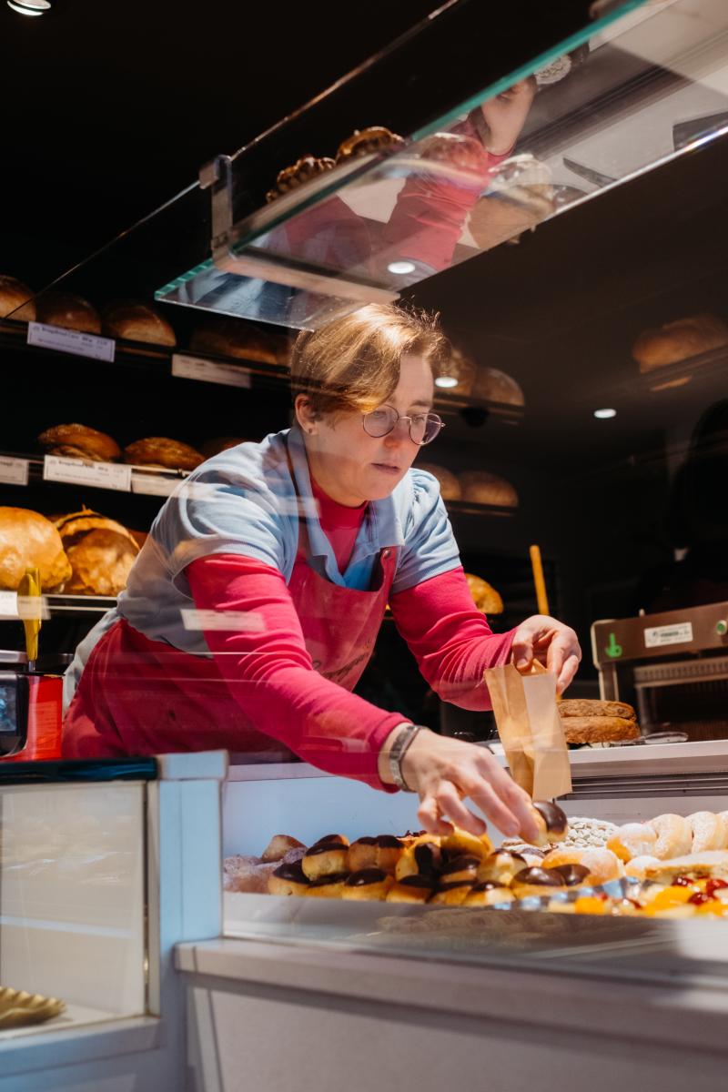 Melissa schikt de toonbank vol lekkers bij bakkerij Terrijn.