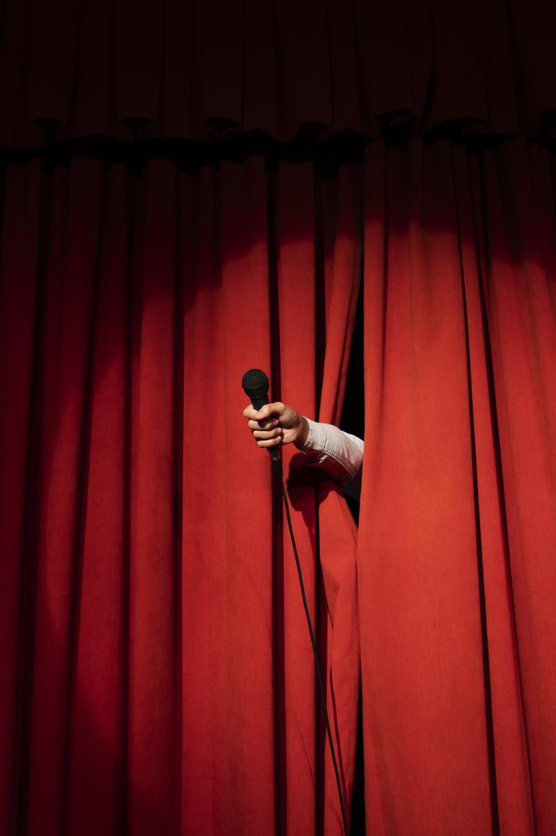 Podiumgordijn met hand door (c)Freepik