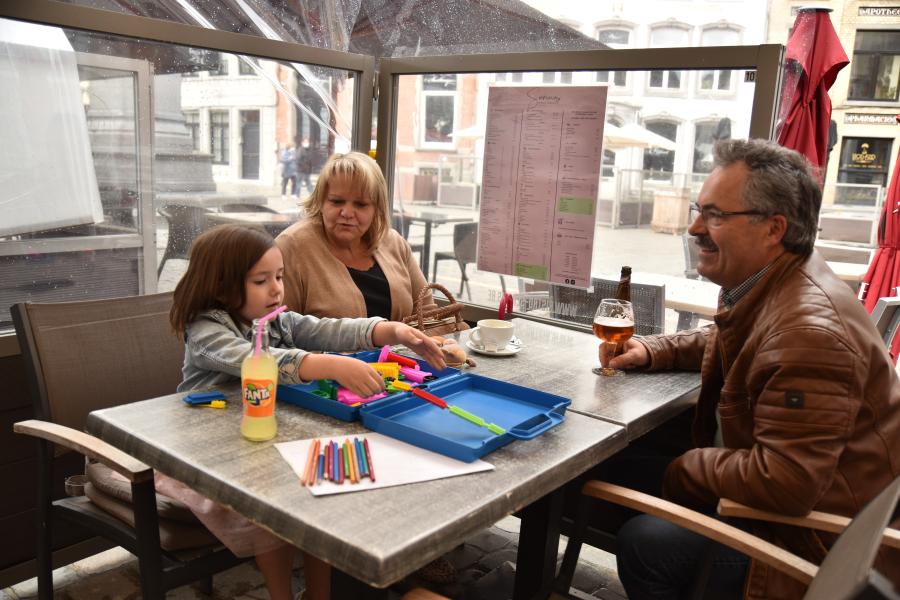 grootouders met hun kleinkind drinken iets op een terras