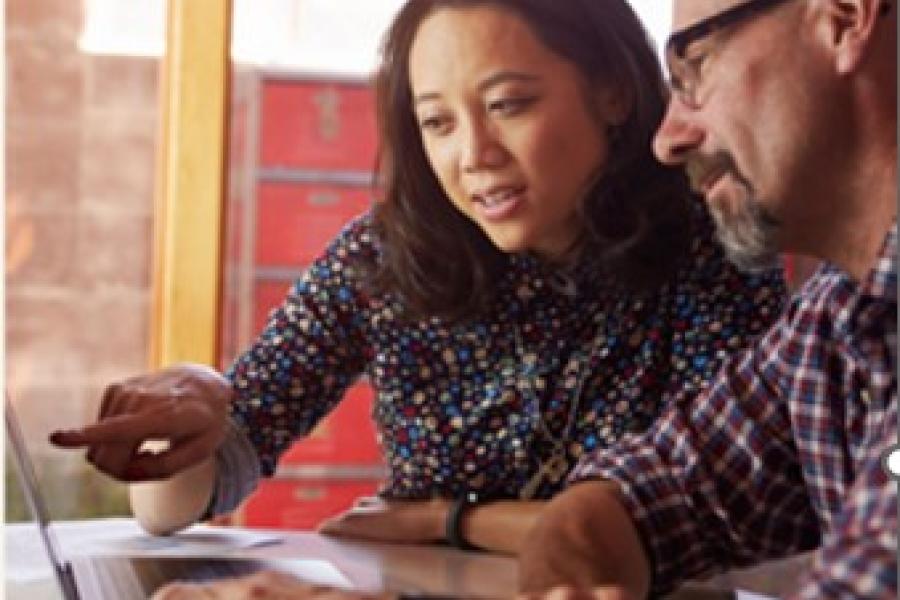 iemand helpt een persoon op  de computer