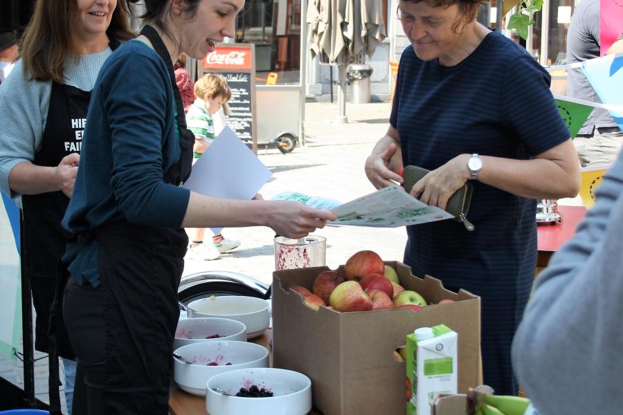 dame krijgt uitleg aan fruitstandje