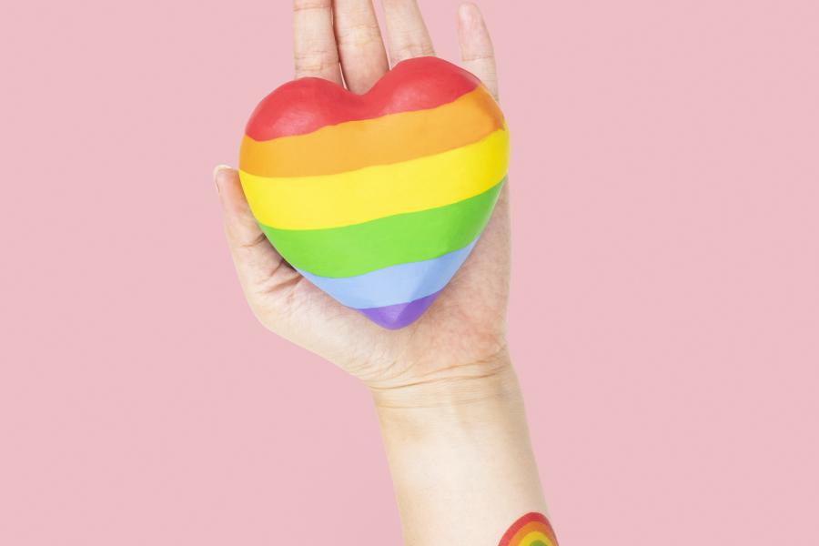 hartje in regenboogkleur ligt in een hand
