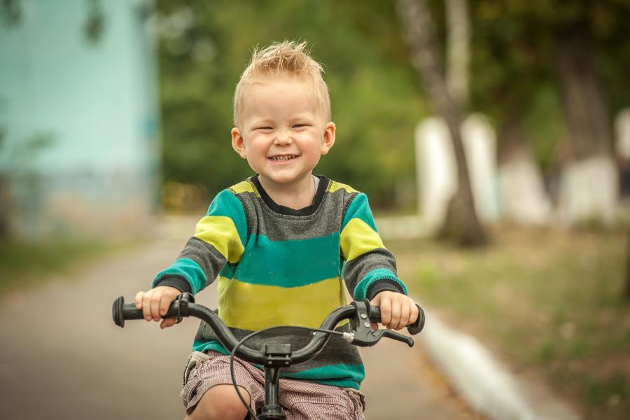 kindje rijdt op de fiets door de speelstraat