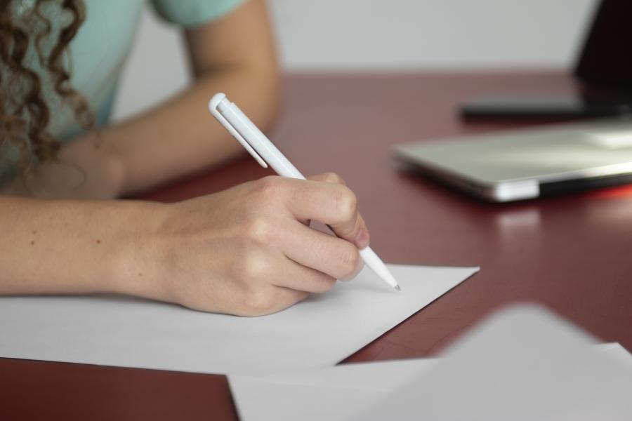 iemand schrijft op papier (c) Freepik
