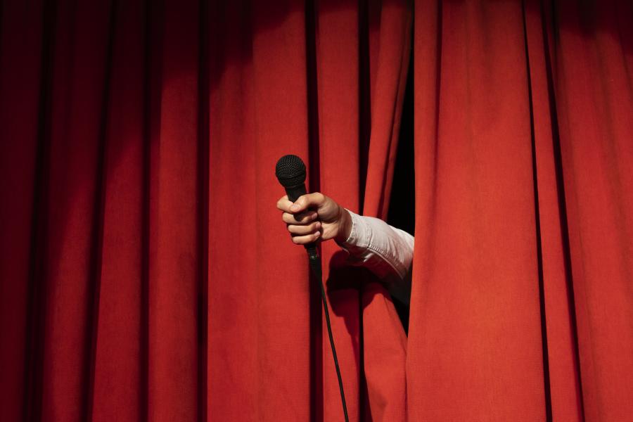 Podiumgordijn met hand door (c)Freepik