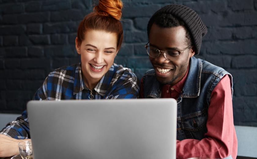 jonge dame en heer zitten achter computer