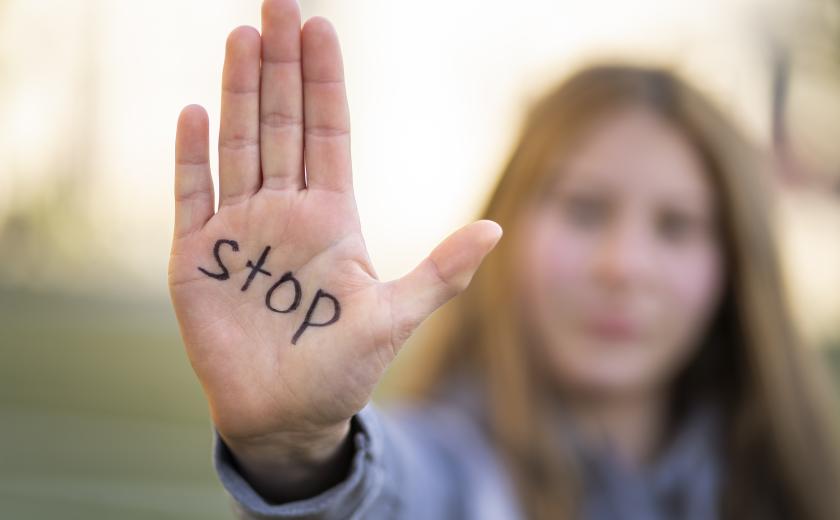 dame houdt hand omhoog met daarop geschreven Stop