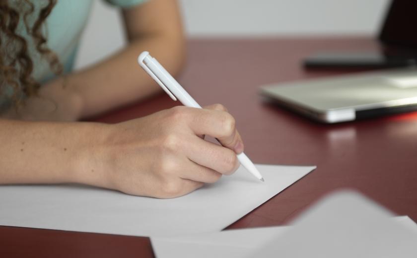 iemand schrijft op papier (c) Freepik