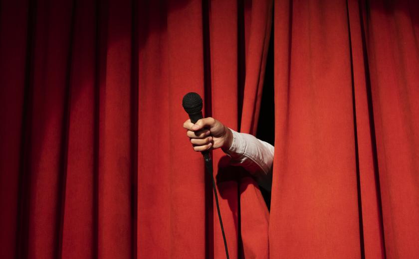 Podiumgordijn met hand door (c)Freepik