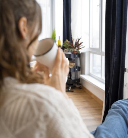 dame drink warme drank met de voeten op de verwarming